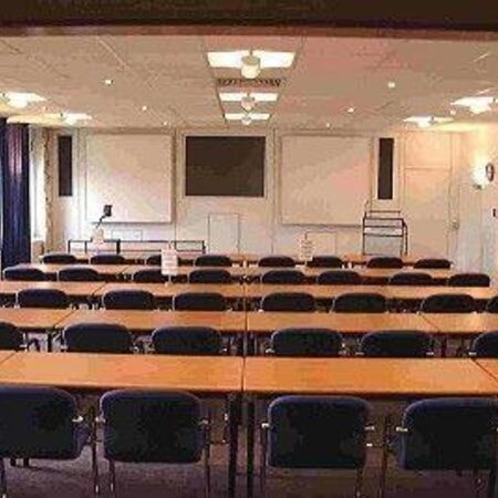 Ein Saal mit vielen Tischen und Sitzplätzen